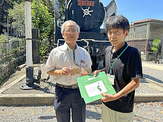 嶋田秀樹さんと動物園所長が本を手に並んで写っている